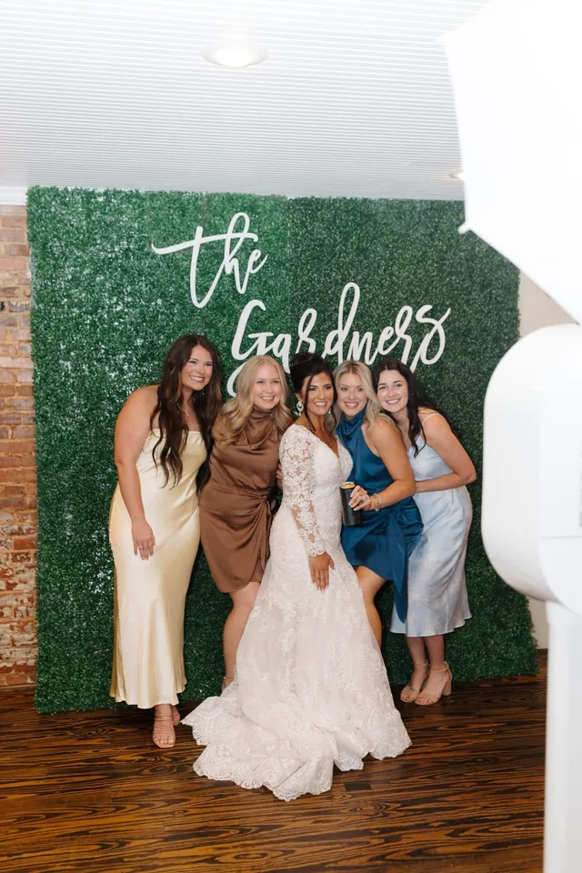 A bride and her bridesmaids posing together in one frame at the open air booth.