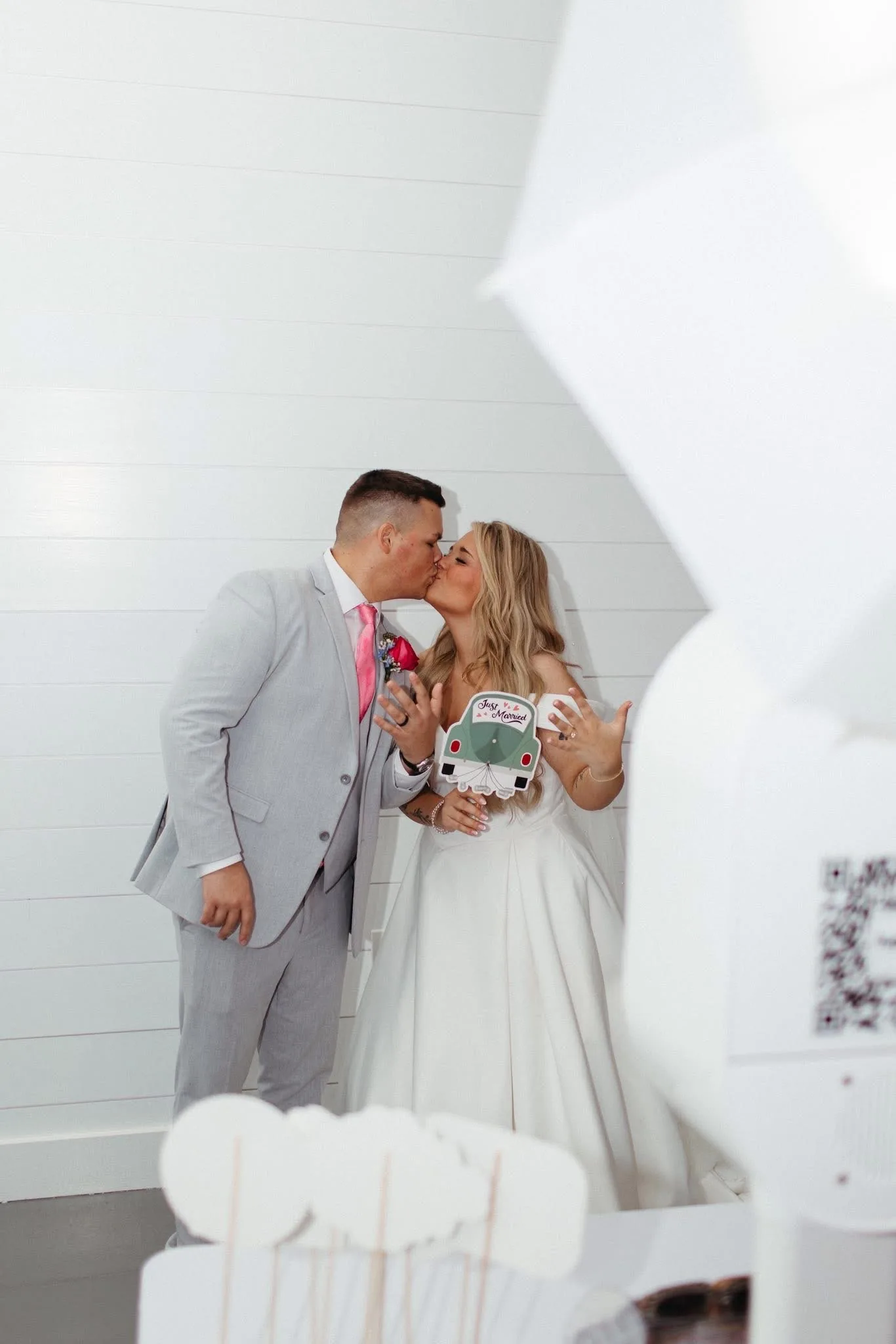 Couple sharing a kiss beside the open air photo booth.
