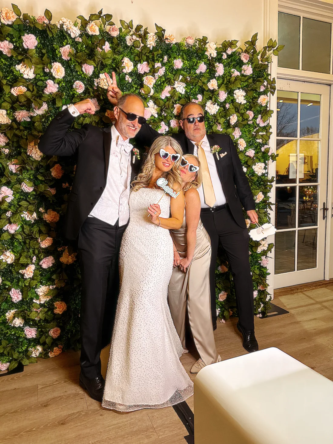 Guests posing in front of the flower wall backdrop.