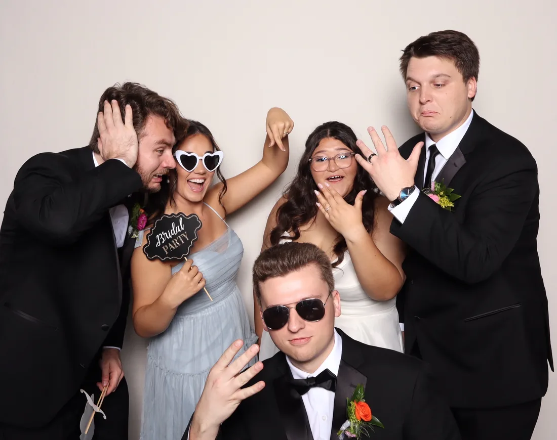Bridal party laughing with props in the photo booth.