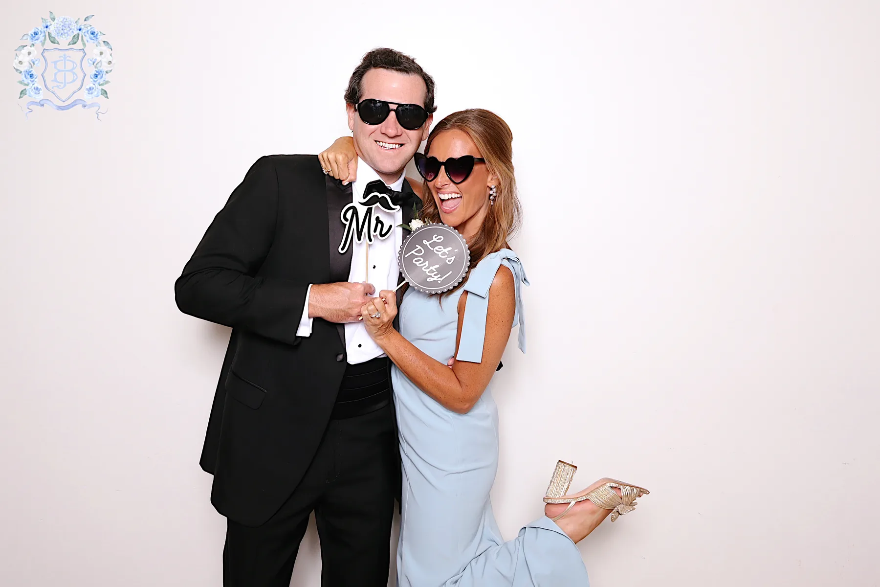 A couple photographed under studio lighting in the Glam booth, against a clean studio backdrop.